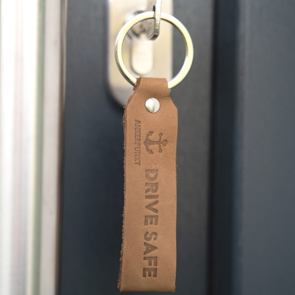 Schlüsselanhänger Drive Safe hellbraun in der Tür hängend