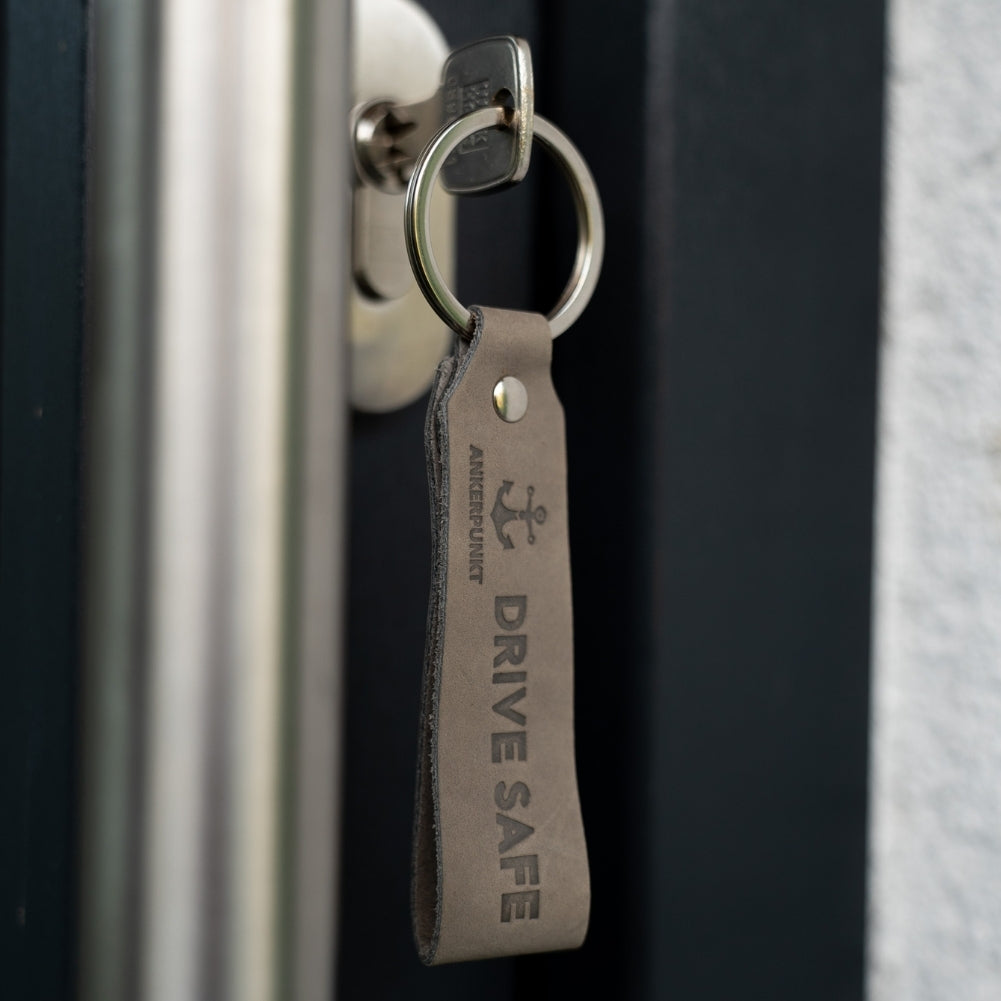 Schlüsselanhänger Drive Safe grau im Türschloss hängend