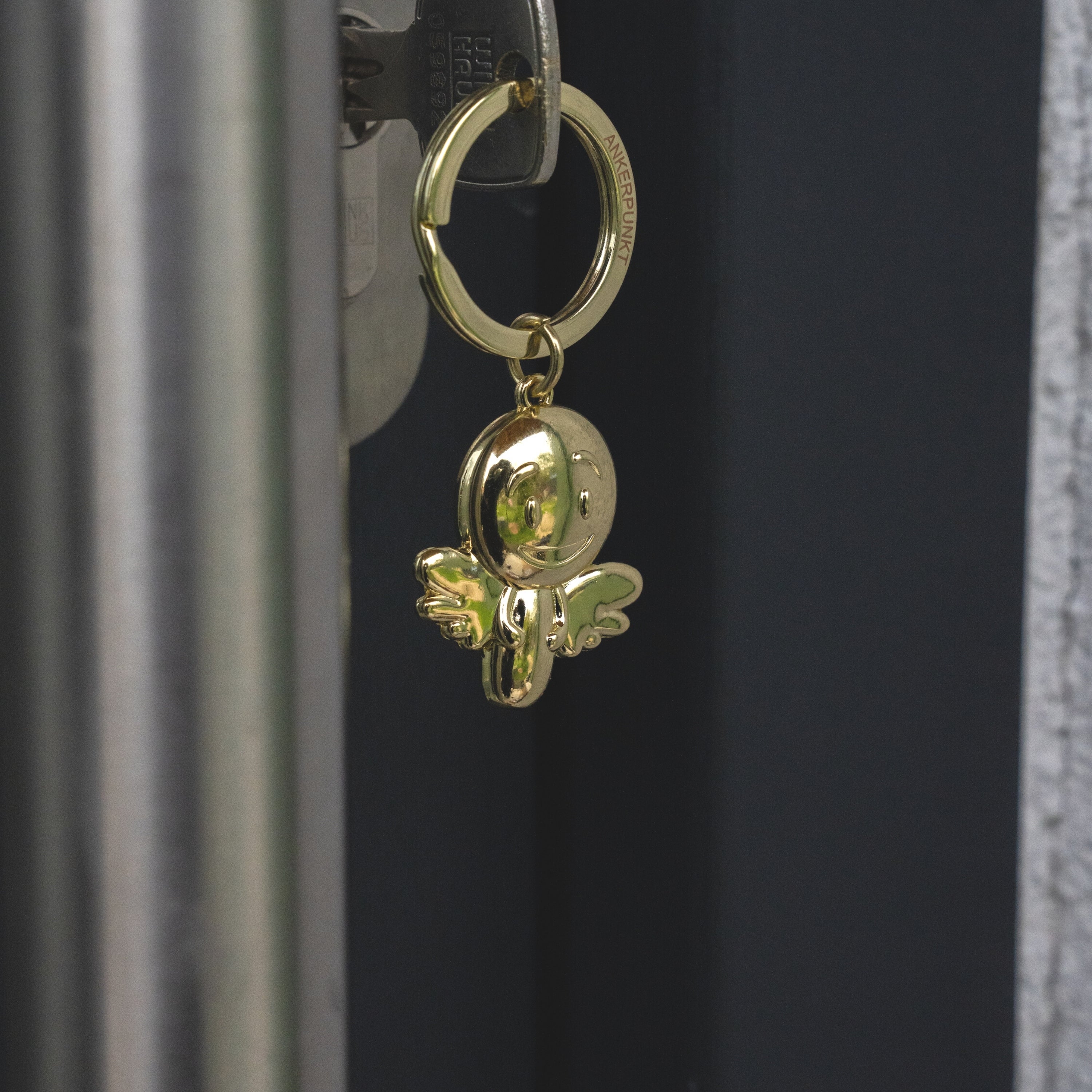 Schlüsselanhänger Engel Smiley gold glänzend im Türschloss hängend