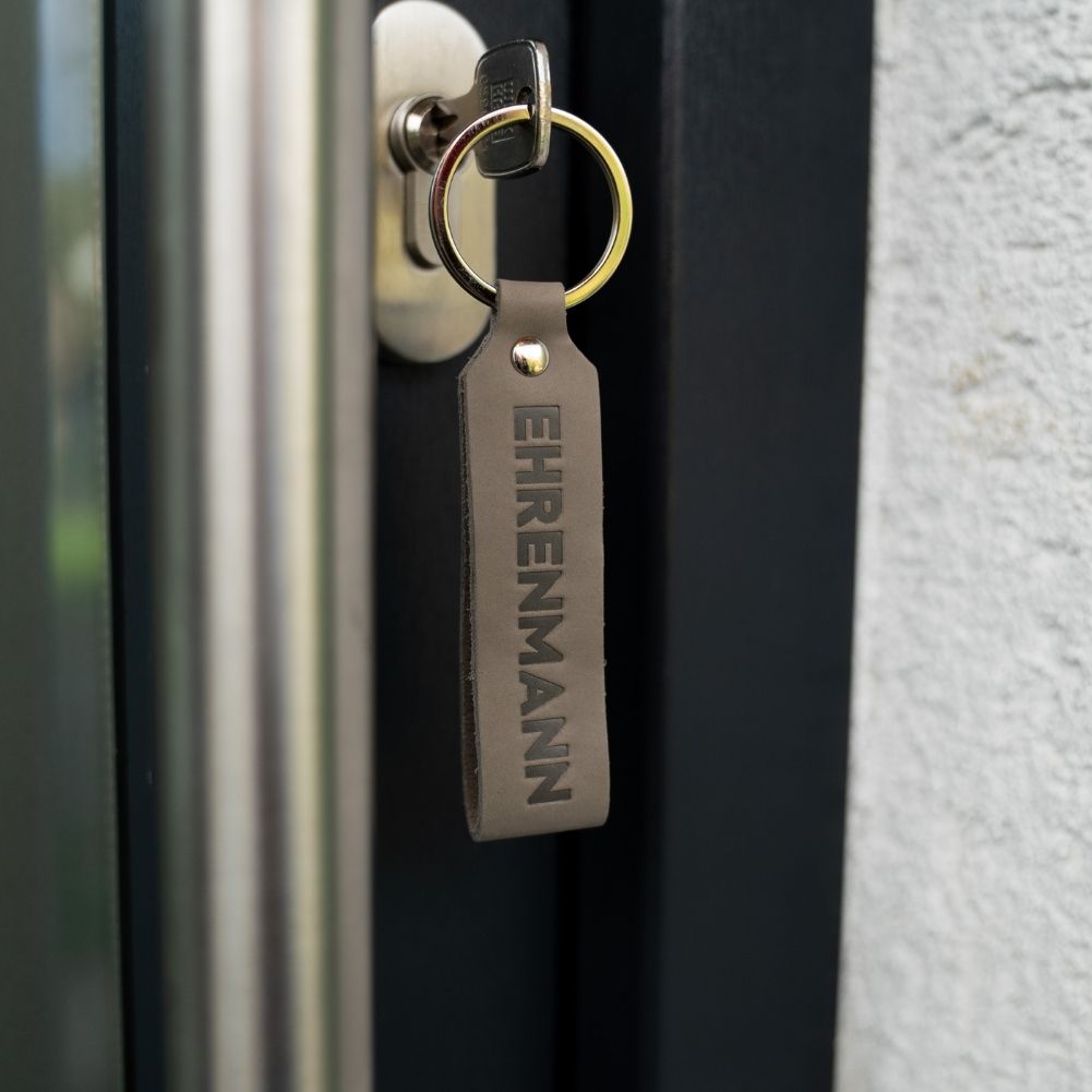Schlüsselanhänger mit Gravur Ehrenmann im Türschloss hängend