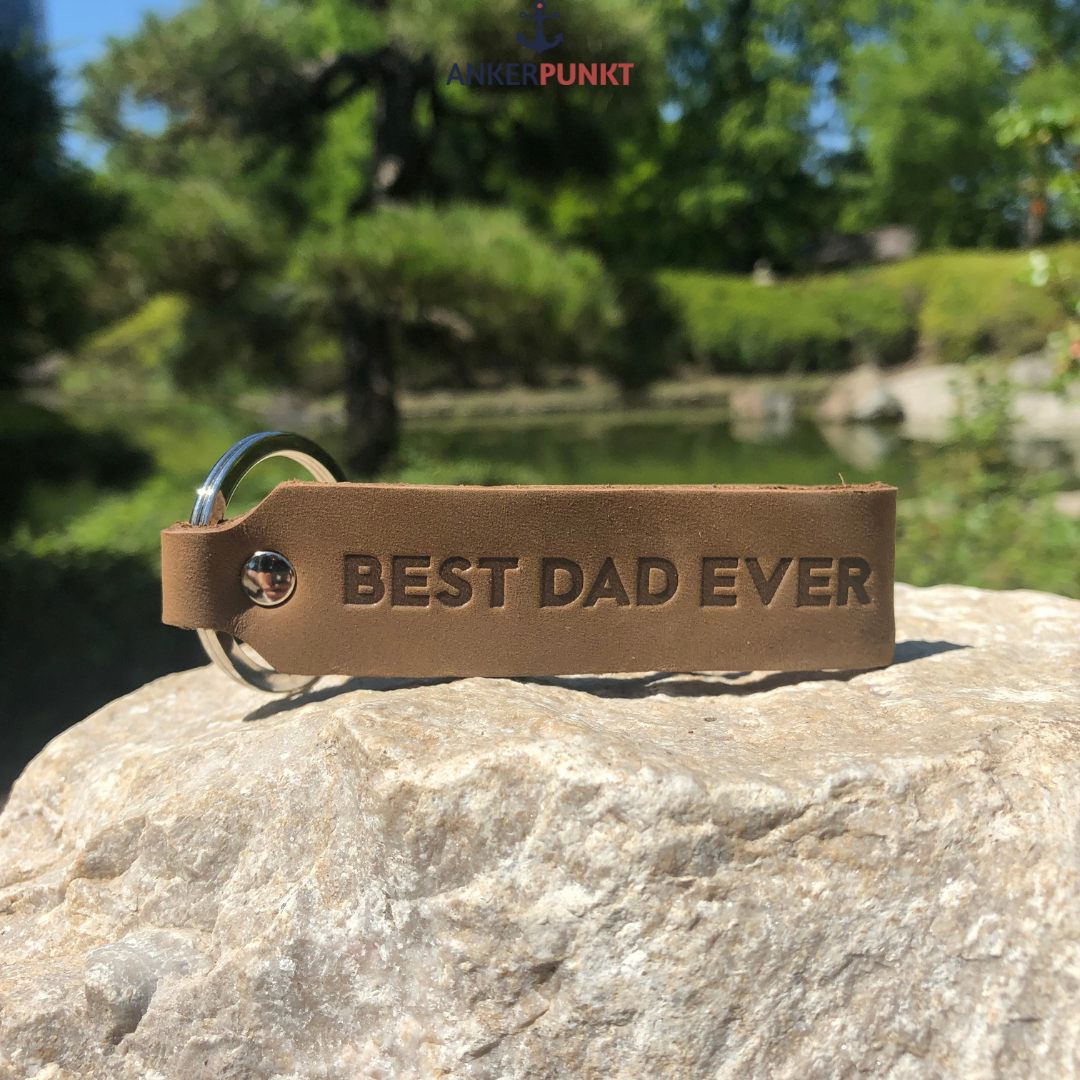 Ankerpunkt Schlüsselanhänger mit Gravur Best Dad Ever dunkelbraun auf Stein im Park