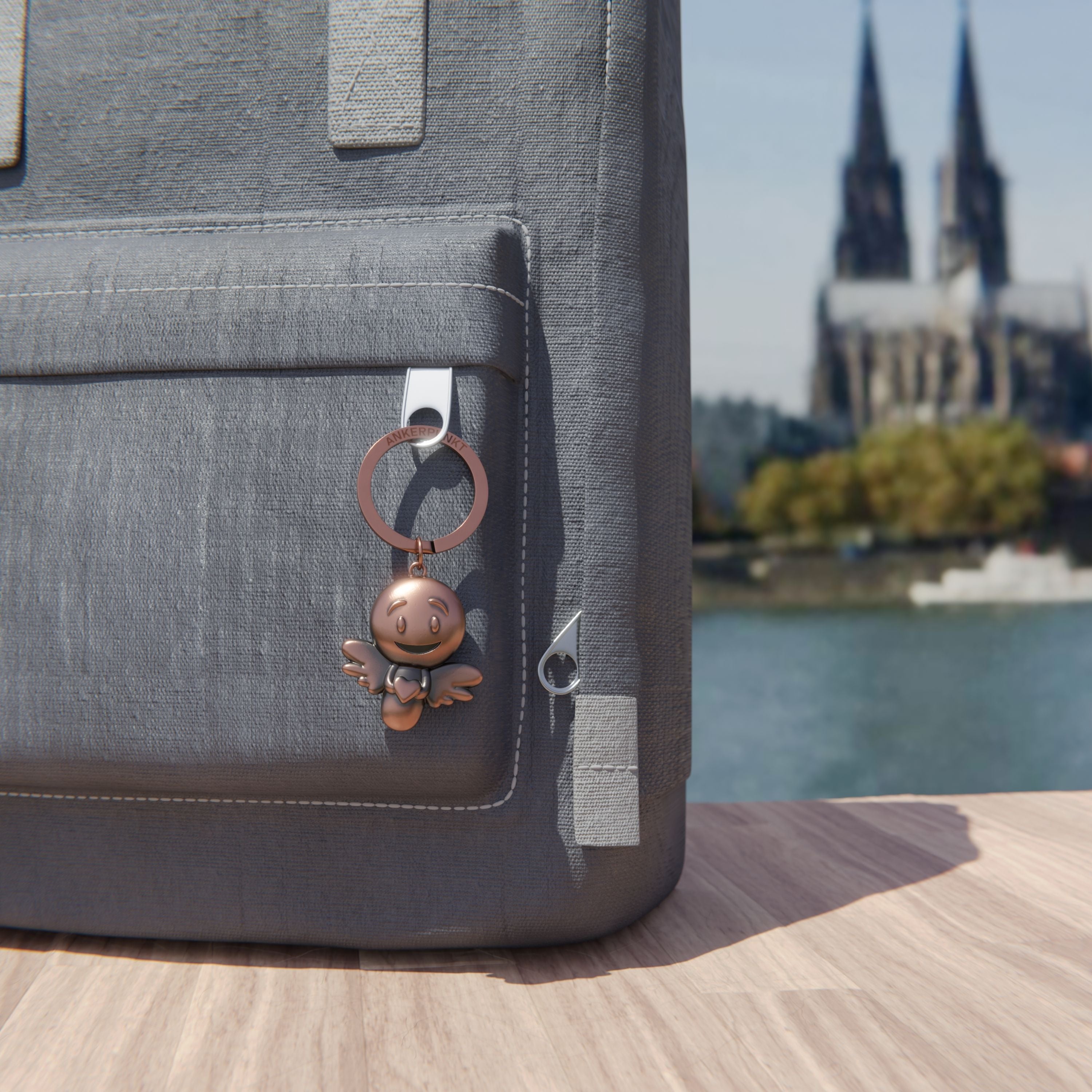 Schlüsselanhänger Lovely bronze vintage am Rucksack am Rhein, im Hintergrund ist der Kölner Dom zu sehen