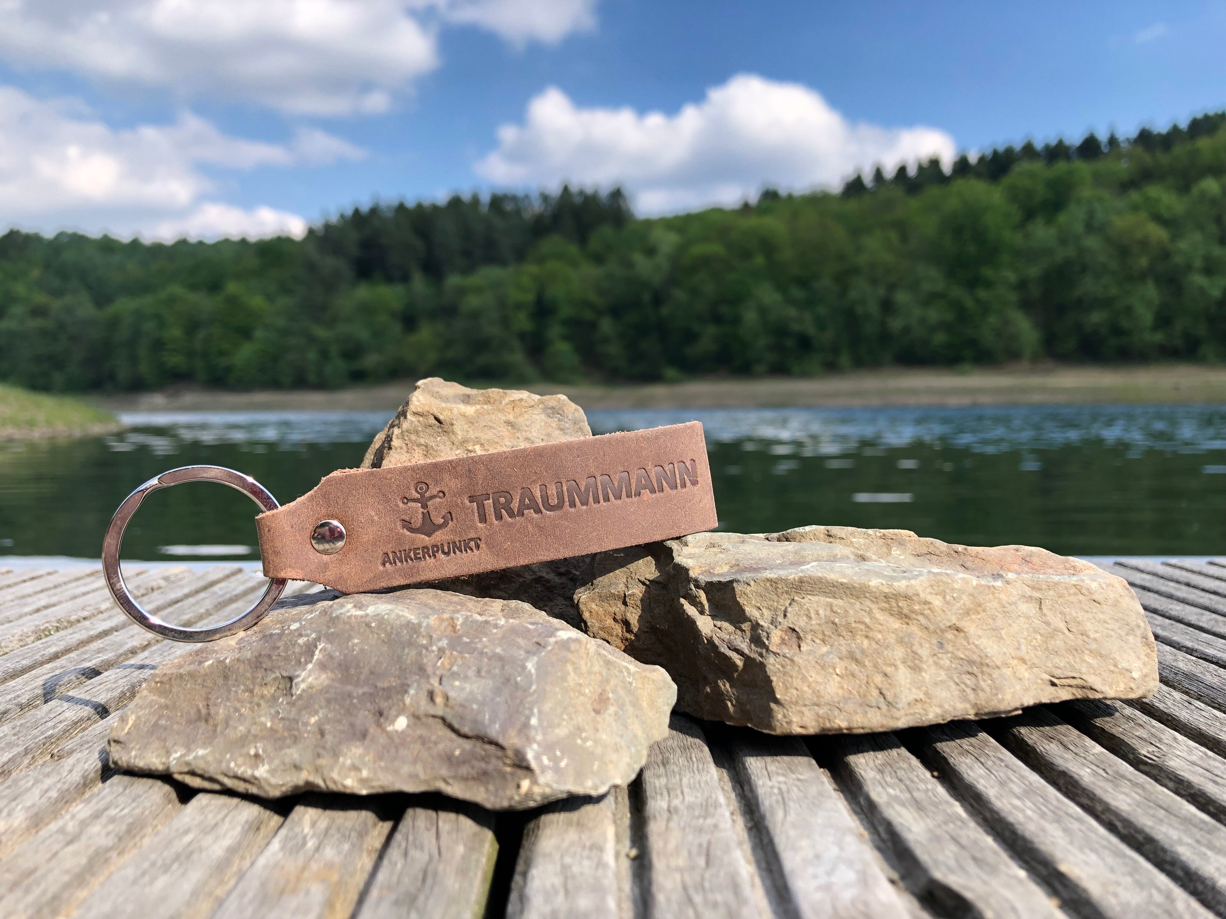 Schlüsselanhänger Traummann dunkelbraun auf Steinen am Rhein