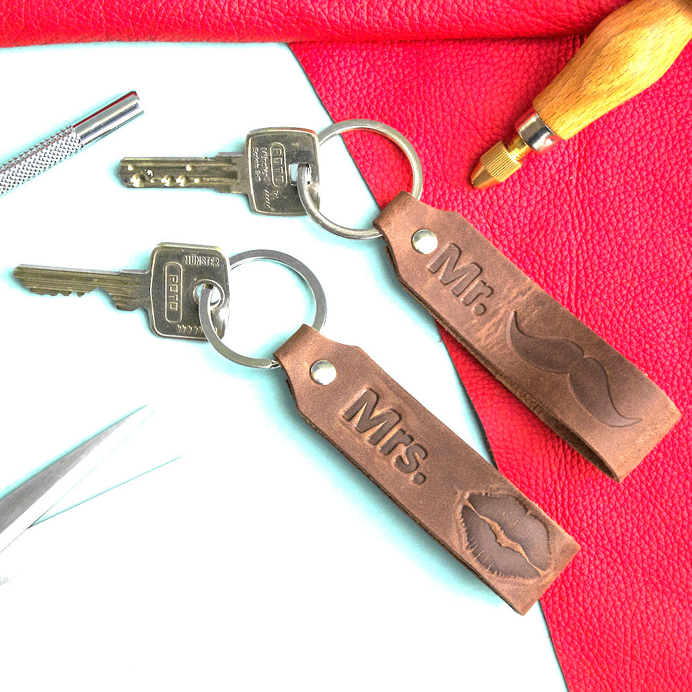 Schlüsselanhänger Mr & Mrs dunkelbraun mit Schlüsseln und Werkzeug auf dem Tisch