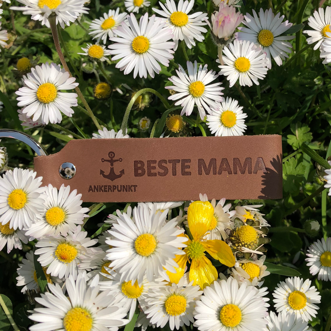 Schlüsselanhänger mit Gravur Beste Mama liegt auf Blumen auf
