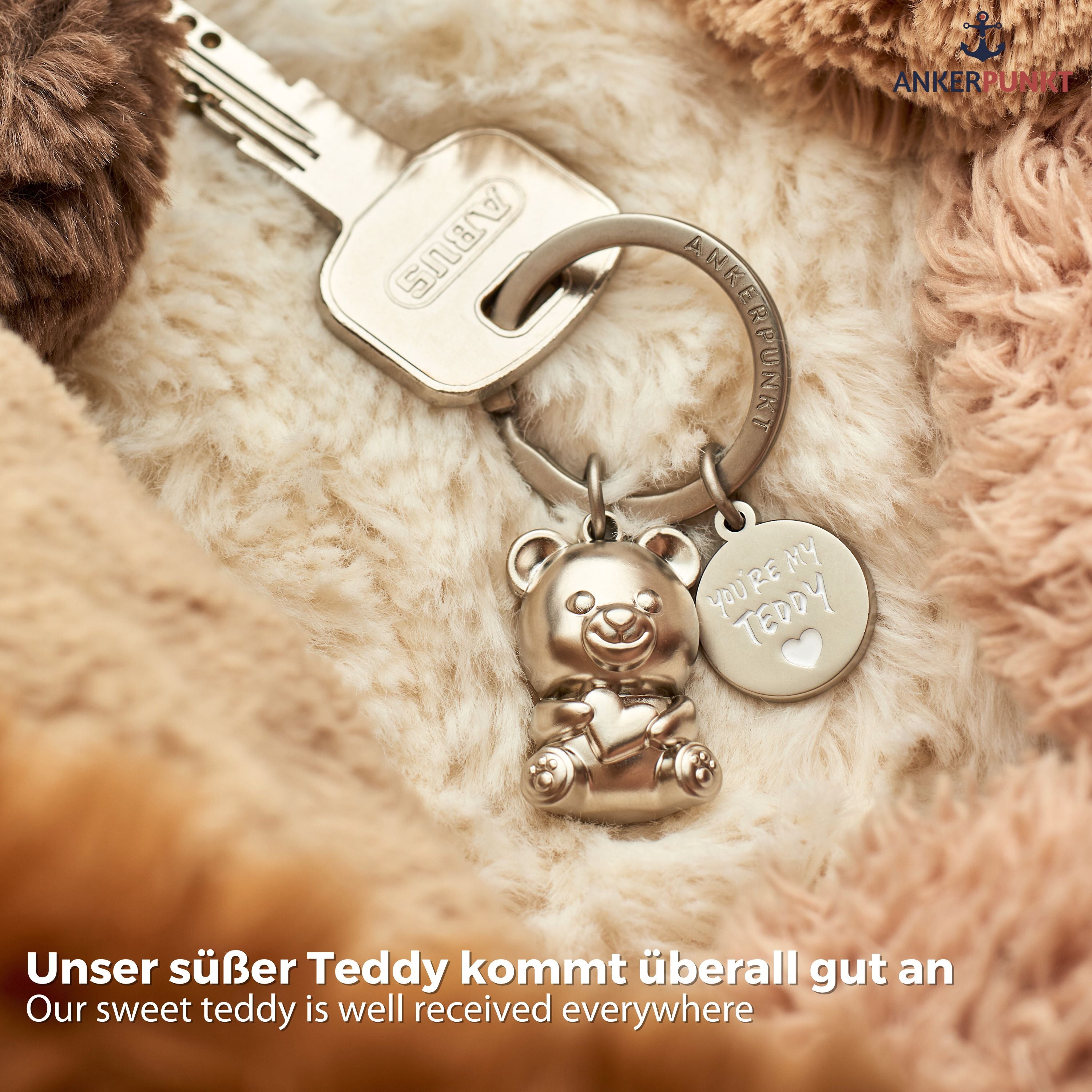 Teddybär Schlüsselanhänger in silbermatt auf Kuscheldecke