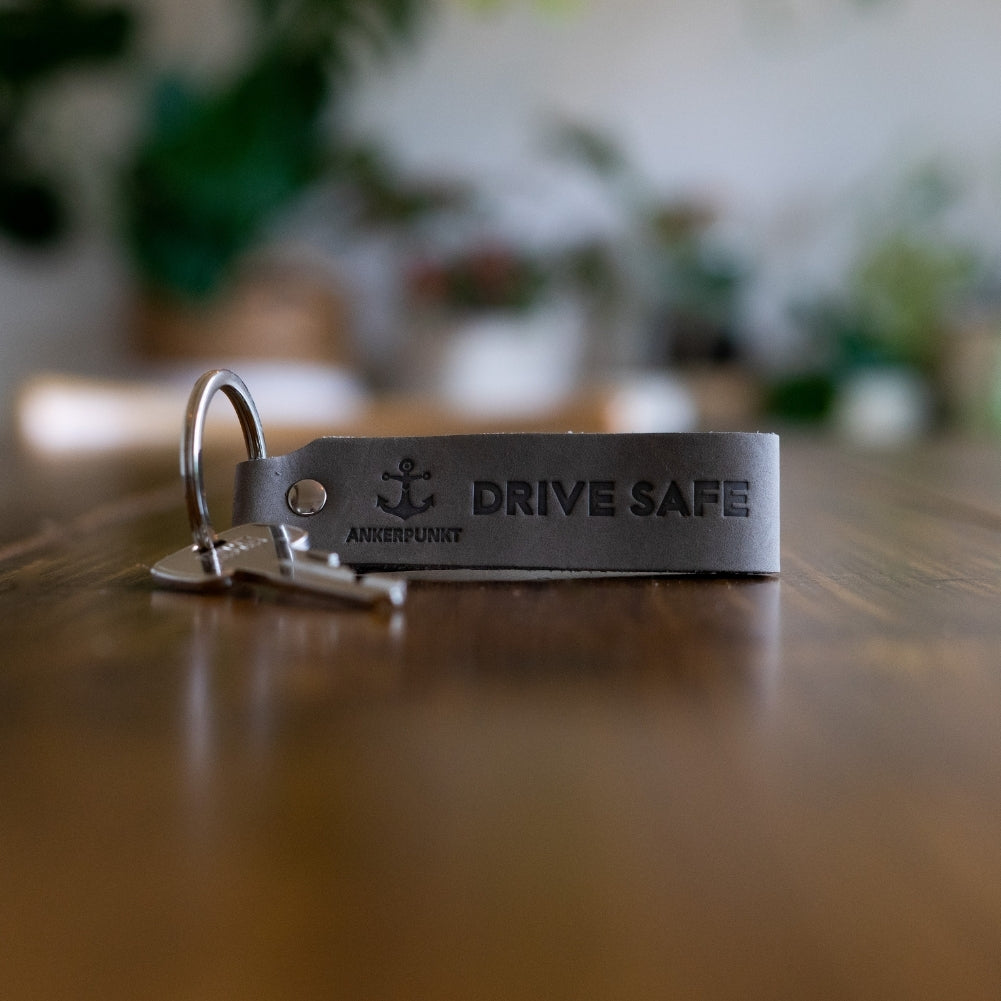Schlüsselanhänger Drive Safe grau auf dem Tisch
