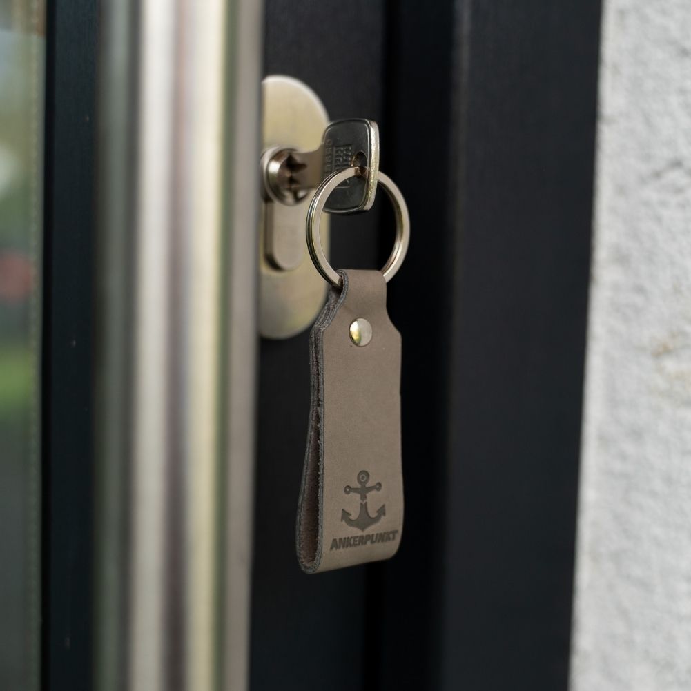 Schlüsselanhänger mit Anker grau in der Tür hängend