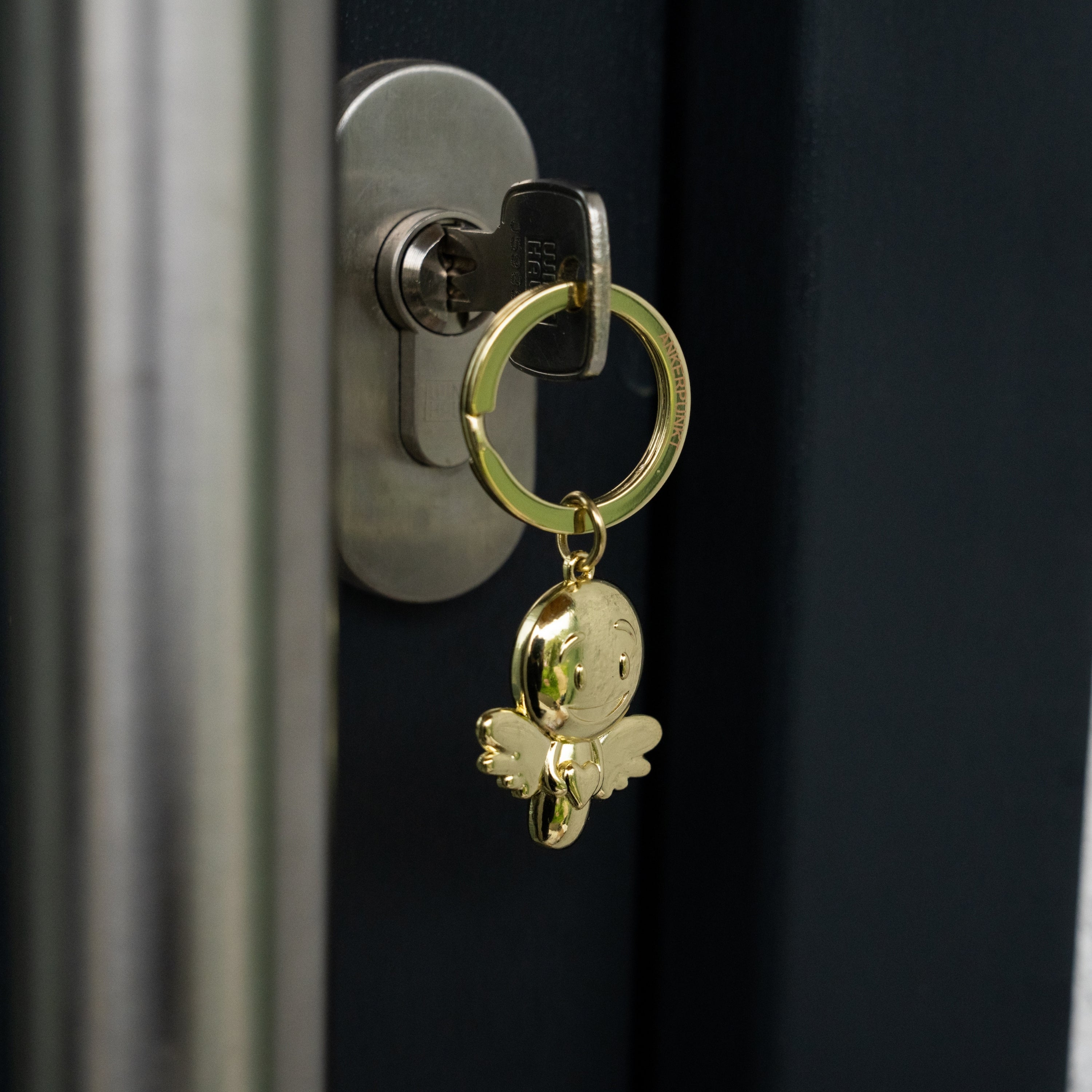 Schlüsselanhänger Lovely gold glänzend im Türschloss hängend