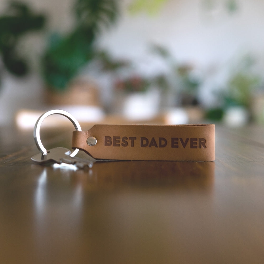 Ankerpunkt Schlüsselanhänger aus Leder mit Gravur Best Dad Ever hellbraun liegt auf Tisch