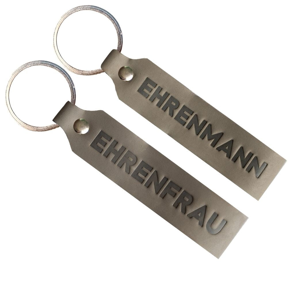 Zwei Schlüsselanhänger mit Gravur Ehrenmann und Ehrenfrau in grau