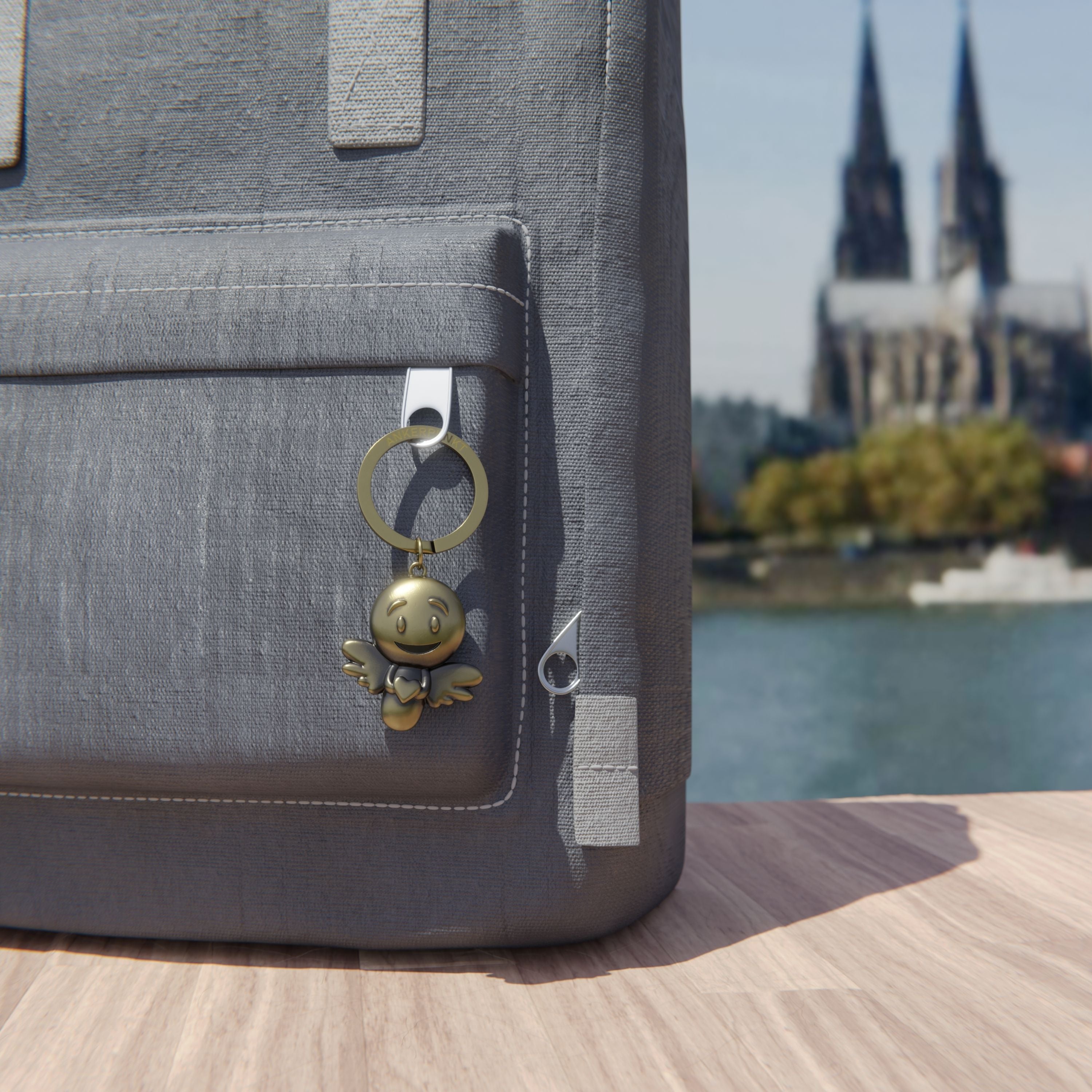Schlüsselanhänger Lovely gold vintage am Rucksack am Rhein, im Hintergrund ist der Kölner Dom zu sehen