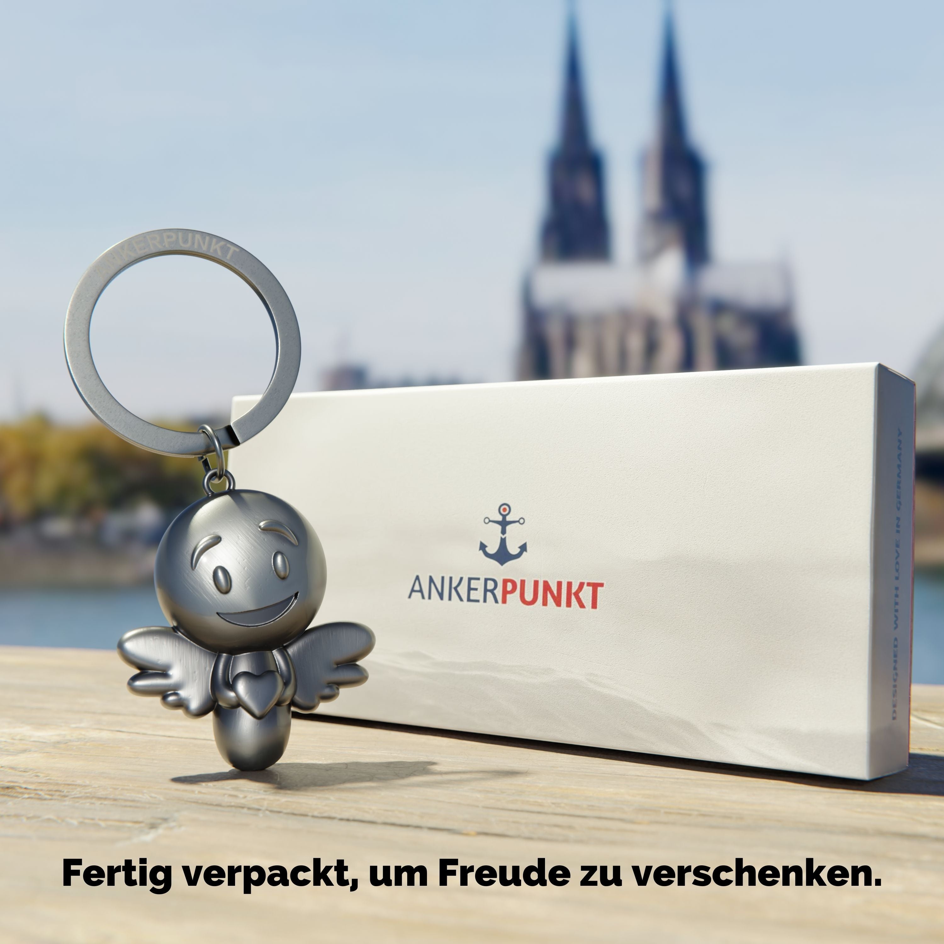 Schlüsselanhänger Lovely silber vintage  mit Verpackung am Rhein, im Hintergrund ist der Kölner Dom zu sehen