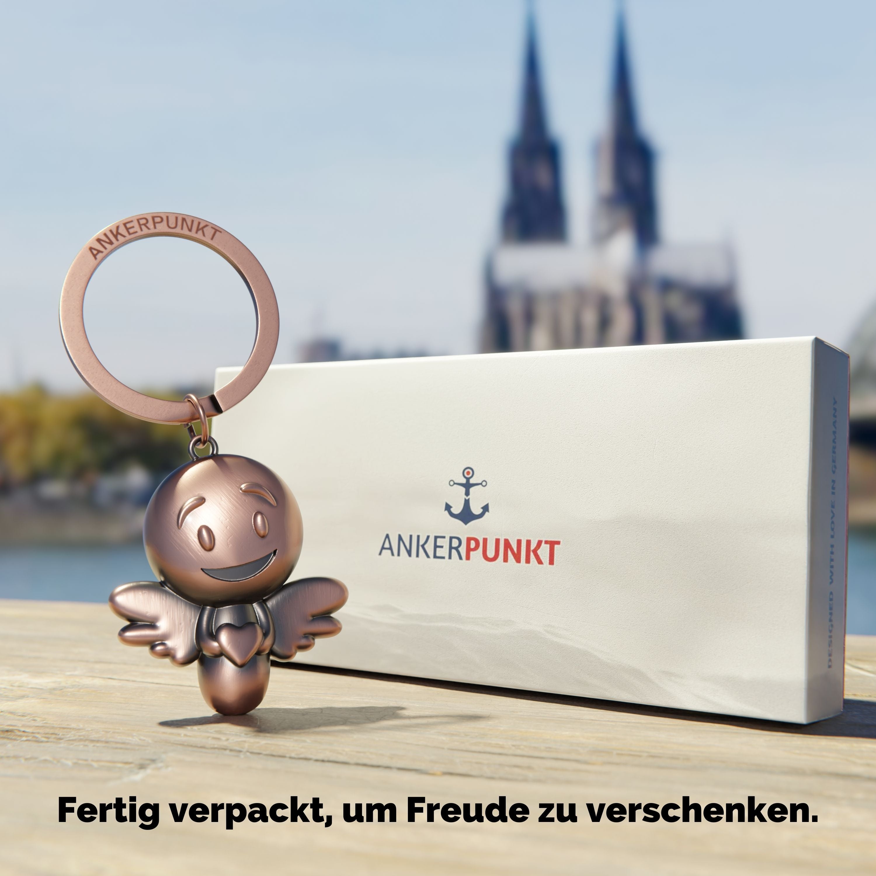 Schlüsselanhänger Lovely bronze vintage mit Verpackung, im Hintergrund ist der Kölner Dom zu sehen
