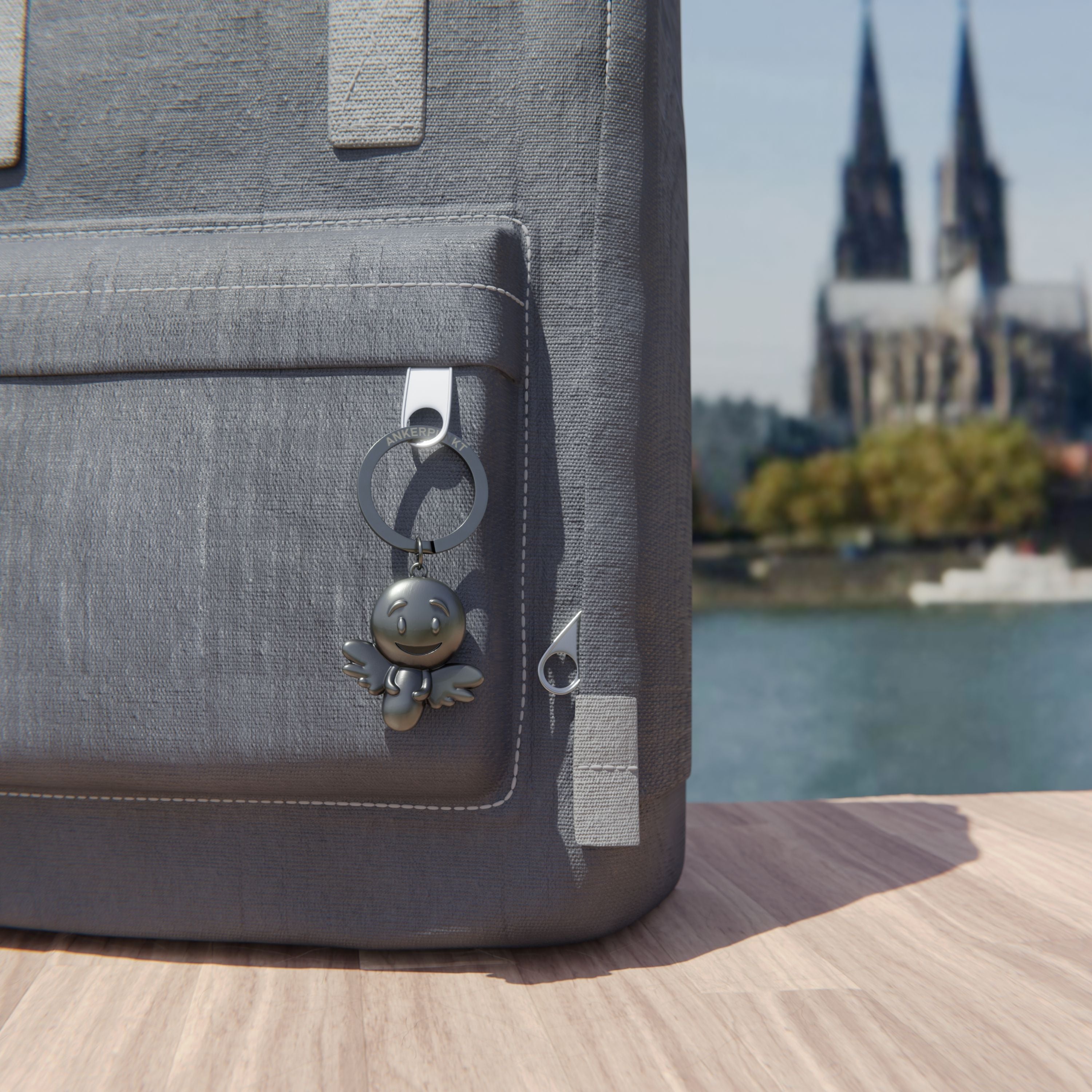 Schlüsselanhänger Engel silber vintage am Rucksack am Rhein, im Hintergrund ist der Kölner Dom zu sehen